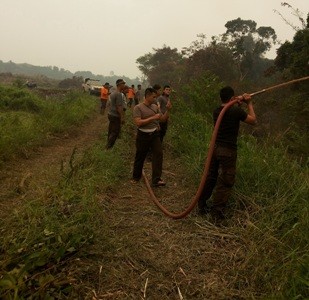 Kepolisian dan pihak PT BBS sedang memadamkan api di lokasi kebakaran lahan PT BBS
